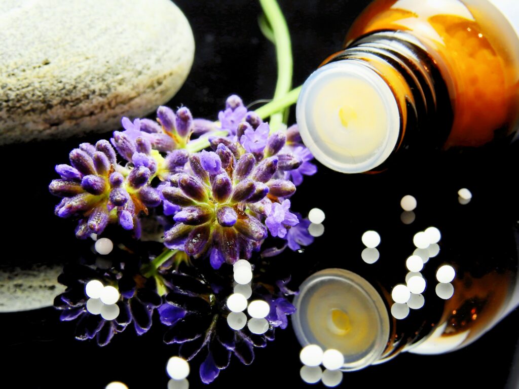 Purple flowers next to bottle of homeopathic medicine